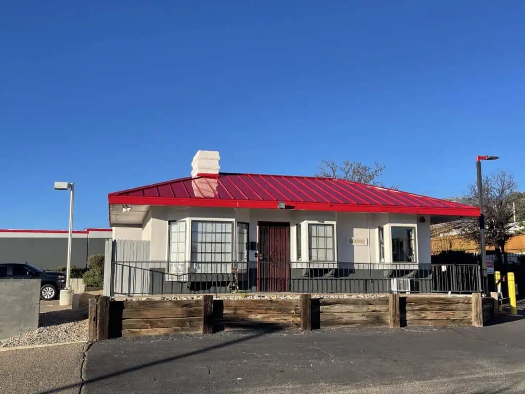 Residential house with fresh white paint and red roof, professional exterior painting services.