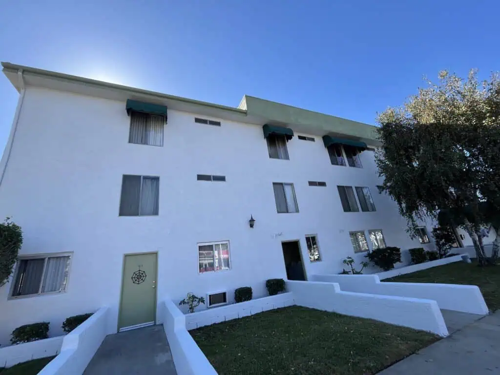 Exterior building painted with fresh white paint, enhancing curb appeal and protection.